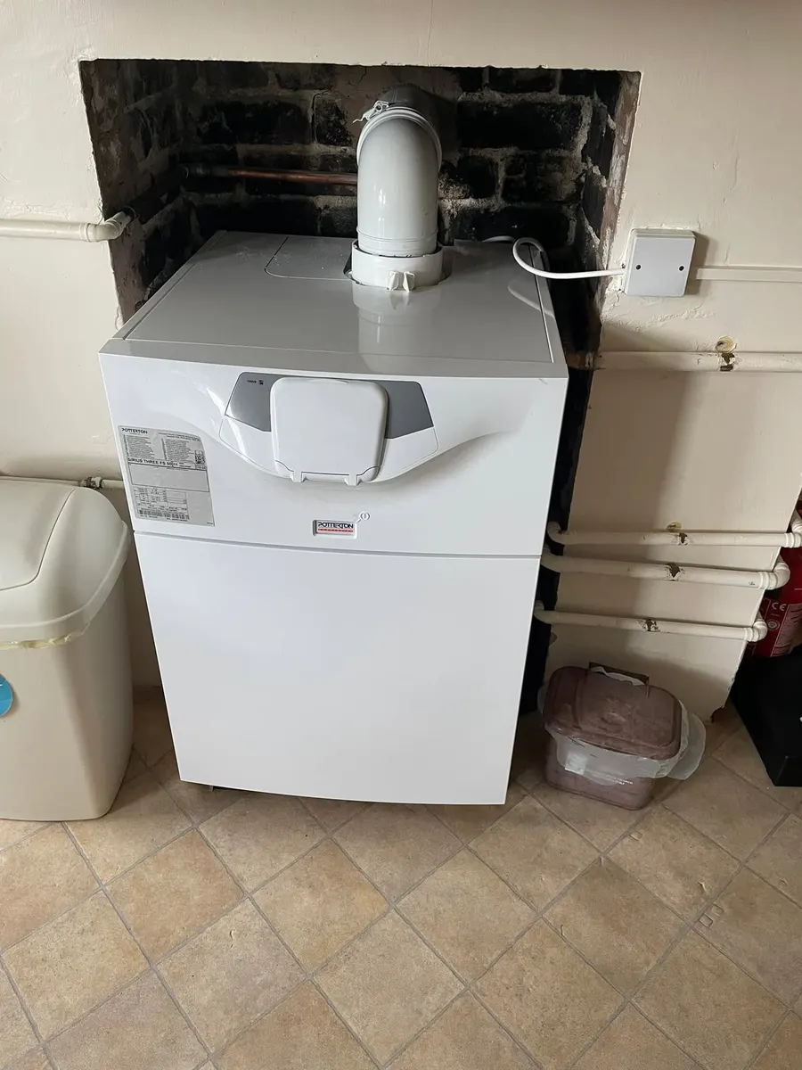 After: new white Potterton floor-standing boiler with a fresh white flue in the fireplace recess
