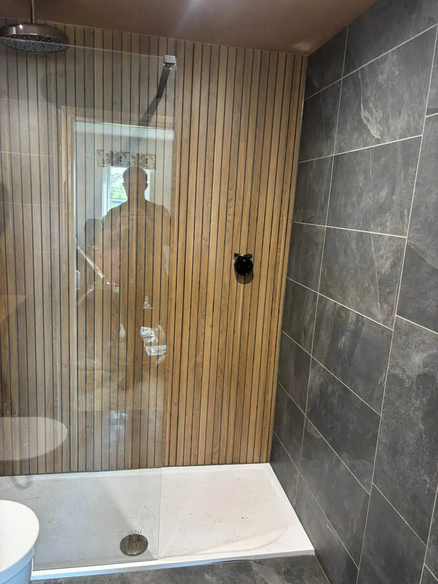 Walk-in shower with wood slat panelling, slate grey tiles and a rain shower head