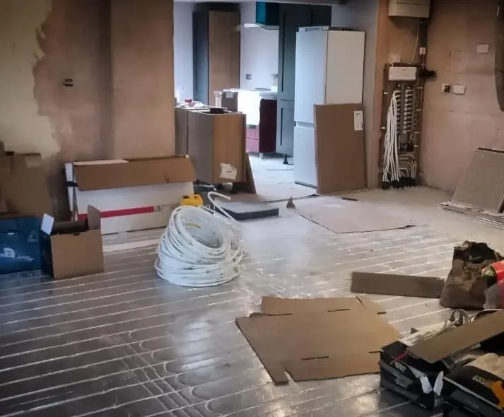 Underfloor heating pipes laid across a kitchen floor during a renovation